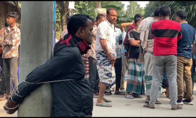 খড় ও পাটকাঠির পালায় আগুন দেওয়ার অভিযোগে  আওয়ামী লীগ নেতার ছেলেকে খুঁটির সঙ্গে বেঁধে মারধর